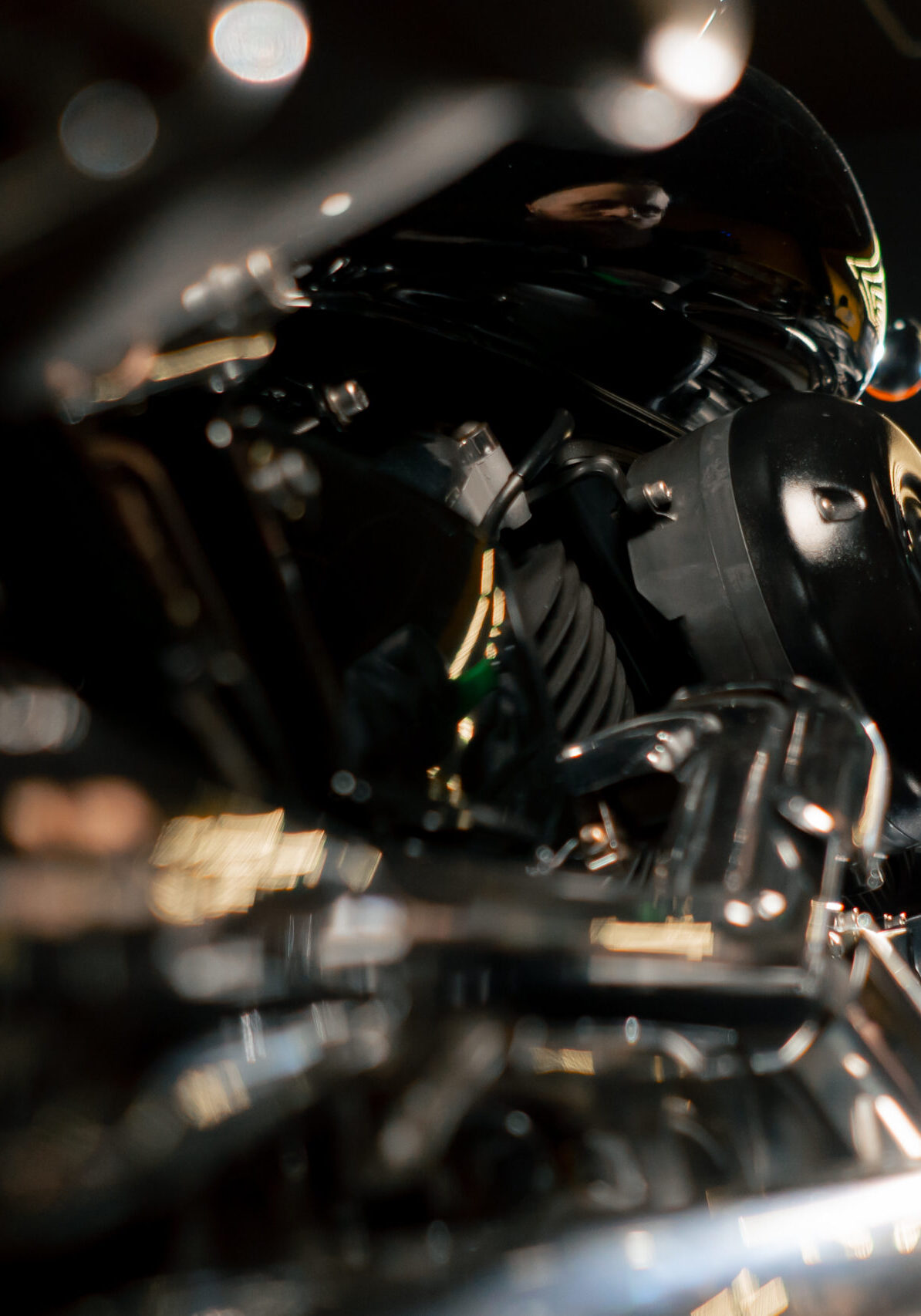 close up In a motorcycle repair shop a mechanic unscrews the bolts on the filter cover